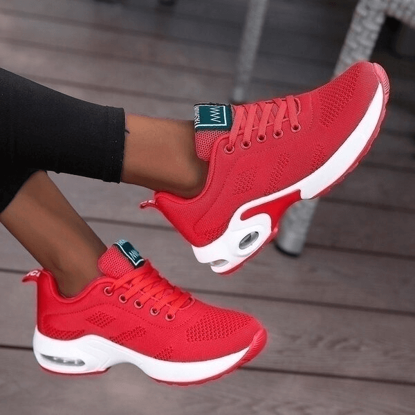 Red breathable women's running shoes with mesh upper and cushioned insole for comfort, featuring a lace-up closure and flat heel.